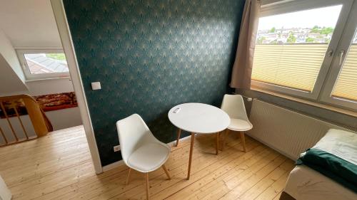 a room with two chairs and a table and a bed at Ferienhaus An der Weinrebe in Bad Hersfeld mit Garten, 2 Bäder, 2 Schlafzimmer & Küche - gratis Parkplätze in Bad Hersfeld