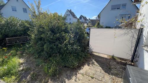 a fence in a yard with bushes and houses at Ferienhaus An der Weinrebe in Bad Hersfeld mit Garten, 2 Bäder, 2 Schlafzimmer & Küche - gratis Parkplätze in Bad Hersfeld