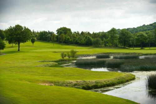 a view of a golf course with a pond at Hotel Woodstock Ennis in Ennis