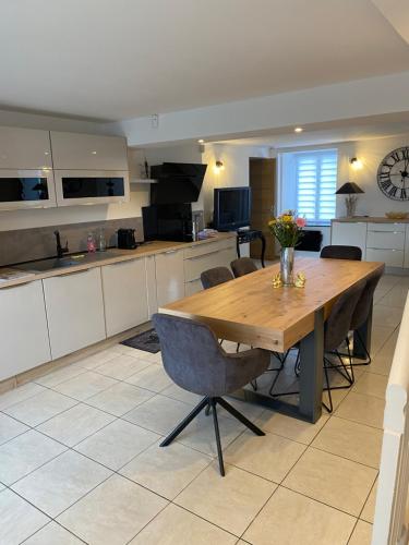 a large kitchen with a wooden table and chairs at Résidence du lion d'or in Conflans
