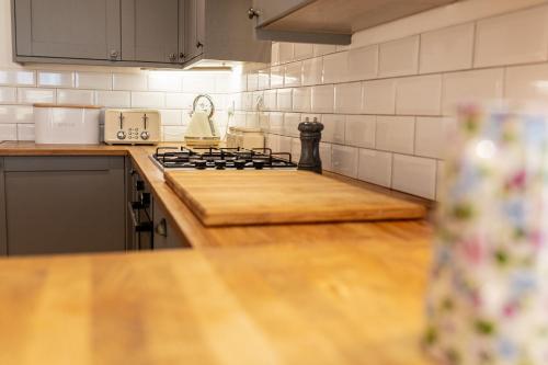 a kitchen with a stove and a counter top at Beautiful Barn Conversion - Orchard Escape for 12! in Cropthorne
