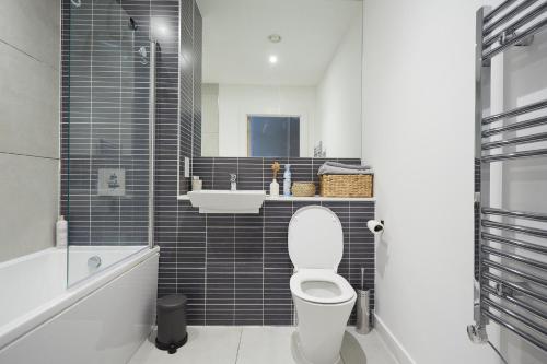 a bathroom with a white toilet and a sink at Vick's house with parking and EV chrgr in Uxbridge