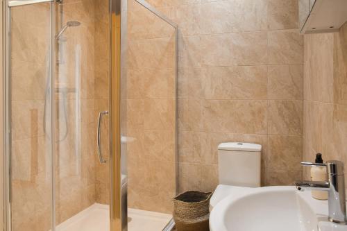 a bathroom with a shower and a toilet and a sink at Beautiful Barn Conversion - Orchard Escape for 12! in Cropthorne