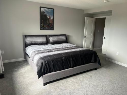 a bed in a bedroom with a picture on the wall at 4 Bedroom Pickering house in Pickering