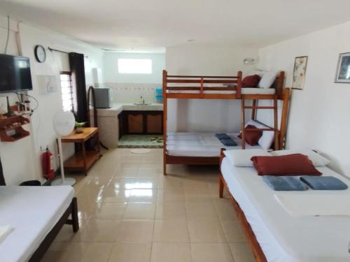 Zimmer mit 2 Etagenbetten und einer Küche in der Unterkunft Virginia Homestay 1North Siargao in Burgos