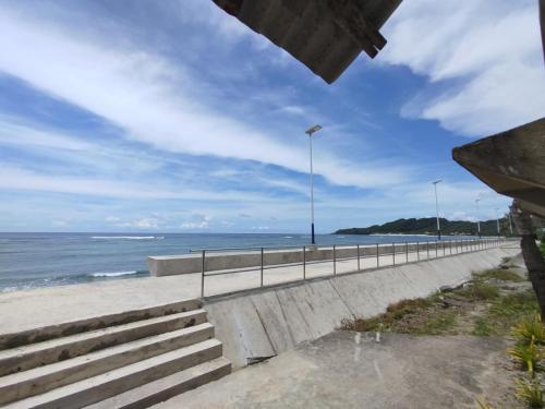 Blick auf einen Strand mit einem Zaun und das Meer in der Unterkunft Virginia Homestay 1North Siargao in Burgos