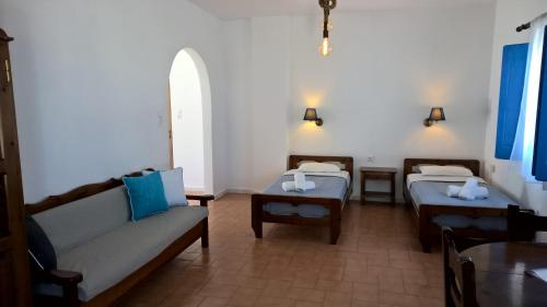 伊亞的住宿－萊奧卡斯緹別墅酒店，客房设有两张床、一张沙发和一张桌子。