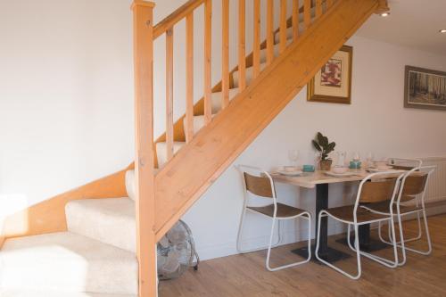 a dining room with a table and a staircase at Beautiful Barn Conversion - Orchard Escape for 12! in Cropthorne
