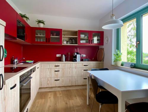a kitchen with red cabinets and a dining table at Krahnberghaus Gotha - Ferien mitten in Deutschland in Gotha