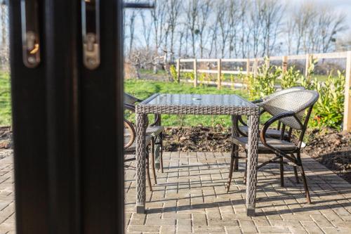 a table and chairs sitting on a patio at Beautiful Barn Conversion - Orchard Escape for 12! in Cropthorne