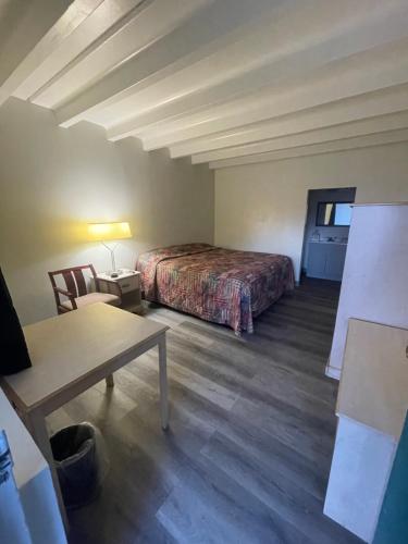 a hotel room with a bed and a table and a desk at Relax Inn in Indianapolis