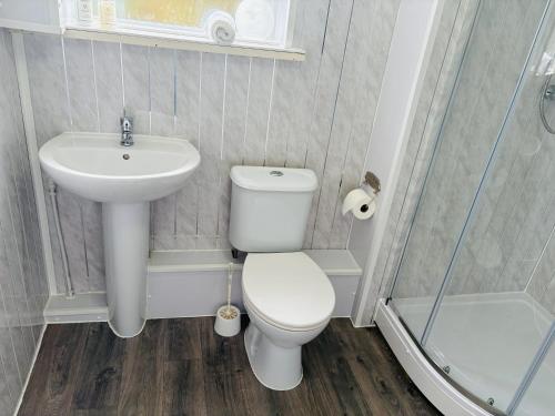 a small bathroom with a toilet and a sink at Captain Howey Hotel in New Romney