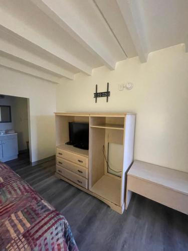 a bedroom with a bed and a dresser with a tv at Relax Inn in Indianapolis