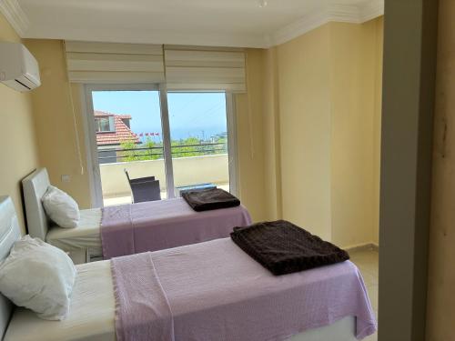 a hotel room with two beds and a window at Begon Villa in Alanya