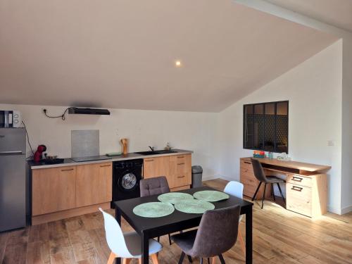 - une cuisine avec une table et des chaises noires dans la chambre dans l'établissement Duplex, Av Charles Trenet, à Narbonne