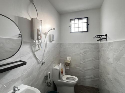 a bathroom with a toilet and a sink and a mirror at J&Y Homestay Kluang in Kluang
