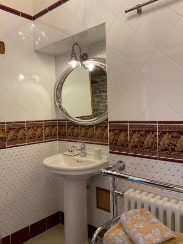 a bathroom with a sink and a mirror and radiator at Le Logis d'Equilly in Équilly