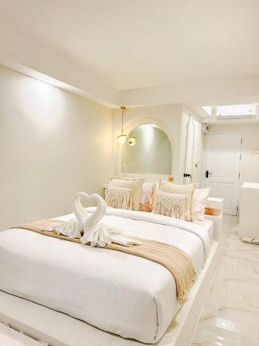 a white bedroom with two beds with white sheets at Evelia Kohsamed in Ao Phutsa