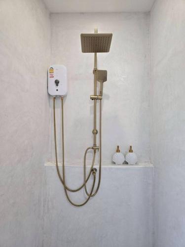 a shower in a bathroom with a shower head at Evelia Kohsamed in Ao Phutsa