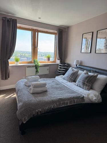 a bedroom with a large bed with towels on it at Luxury Cove at the Docks in Leeds