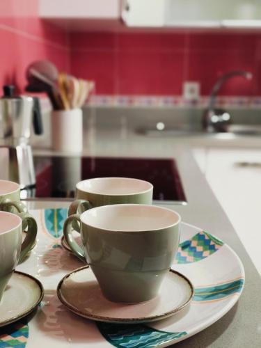 three cups and saucers on a counter in a kitchen at La Casa del Muelle in Huelva