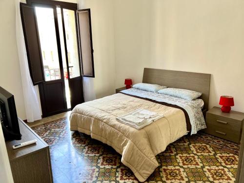 a bedroom with a bed and a tv and a window at Trapani Centro Mare in Trapani