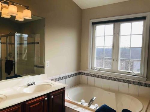 a bathroom with a tub and a sink and a window at Maple Lawn Gem -sunny townhouse 3 bedrooms in Laurel