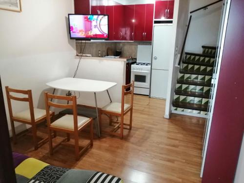 a small kitchen with a table and chairs and a refrigerator at Roses in Roses