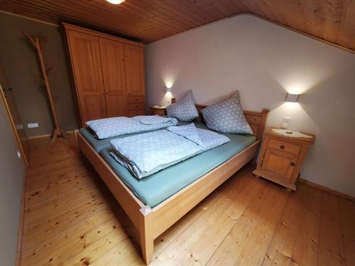 a bedroom with a bed and a wooden floor at Biohof Dimper - HühnerNest in Saulgrub