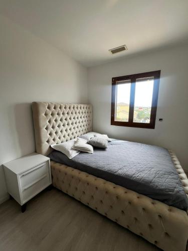 - une chambre avec un lit doté d'une tête de lit touffetée et d'une fenêtre dans l'établissement Immense villa avec piscine, à Vergèze
