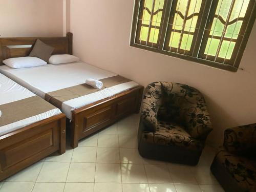 a small bedroom with a bed and a chair at GB Royal Stay Nuwara Wewa in Nikawatawana