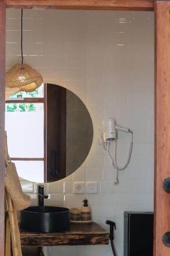 a kitchen with a sink and a mirror on the wall at Vesuvio Loft Private Pool By Casa Kapuas in Gili Trawangan