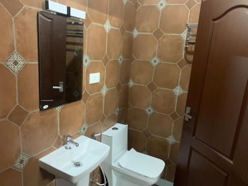 a bathroom with a toilet and a sink and a mirror at Eden Casa in Mararikulam