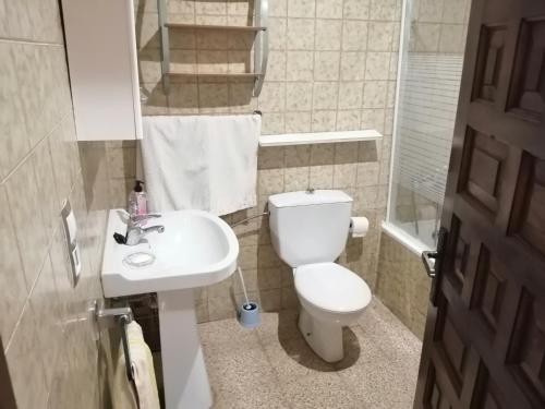 a small bathroom with a toilet and a sink at Roses in Roses