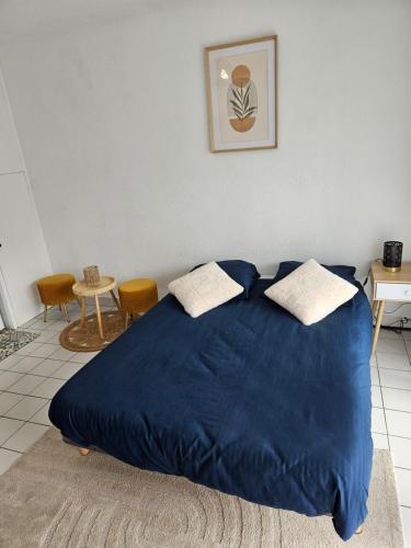 - un lit avec une couverture bleue dans l'établissement Le Relax Studio, à Cherbourg en Cotentin