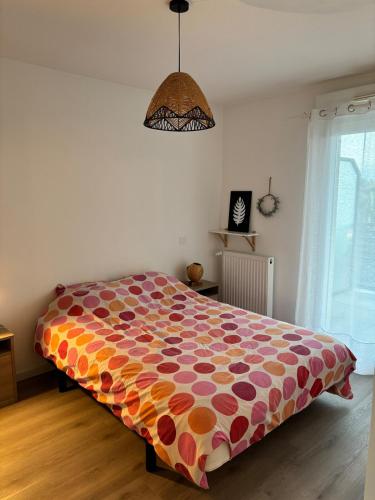 - une chambre avec un grand lit et une couette colorée dans l'établissement 2 pièces lumineux, terrasse exposée sud, proche mer, à Saint-Nazaire