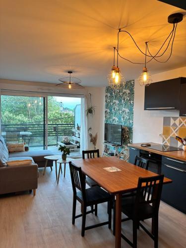 une cuisine et un salon avec une table et des chaises dans l'établissement 2 pièces lumineux, terrasse exposée sud, proche mer, à Saint-Nazaire