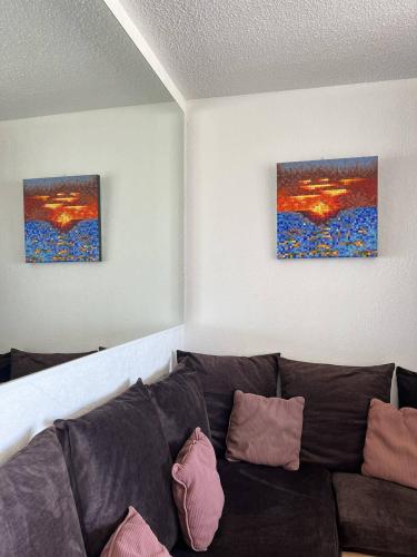 - un salon avec un canapé et deux tableaux dans l'établissement Appartement MALIBU - Héliopolis O14 - Luxe - 2 personnes, au Cap d'Agde