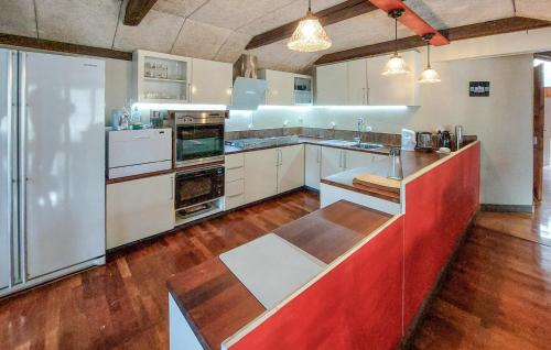 a large kitchen with white appliances and wood floors at Stunning Apartment In Åsljunga in Åsljunga
