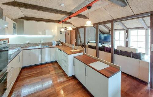 a large kitchen with white cabinets and a bed at Stunning Apartment In Åsljunga in Åsljunga