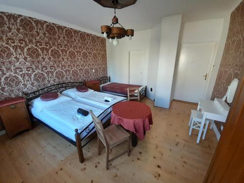 a bedroom with a bed and a table and chairs at Ubytování pod Věží in Teplice nad Metují