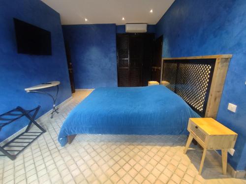 - une chambre bleue avec un lit bleu et une table dans l'établissement Chambre 4, Riad 3 Couple only au village naturiste, au Cap d'Agde