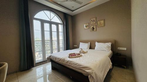 a bedroom with a bed with a stuffed animal on it at Hari Leela fort view palace in Chittaurgarh