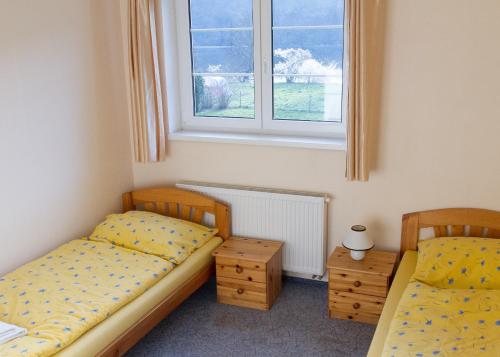 two twin beds in a room with a window at Guest House Kaskáda in Vrané nad Vltavou