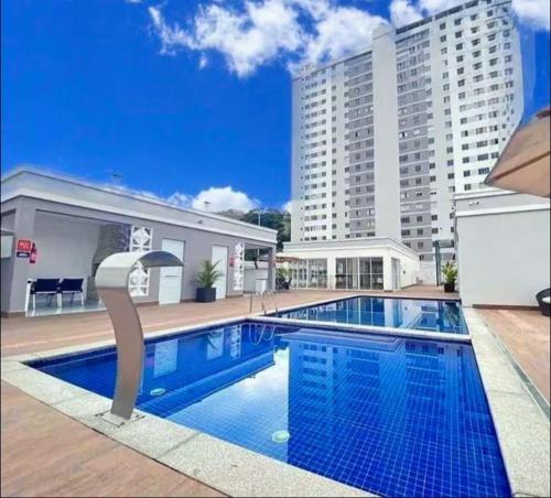 a large swimming pool in front of a building at Acomodação perfeita no Aeroporto in Juiz de Fora