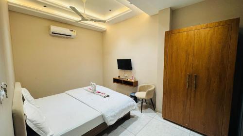 a hospital room with a bed and a wooden door at Hari Leela fort view palace in Chittaurgarh