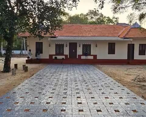 a house with a cobblestone road in front of it at Eden Casa in Mararikulam