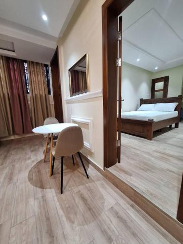 a room with a bed and a table and chairs at COD Haven Ventures Apartments in Madina