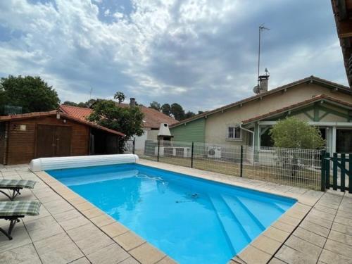 une grande piscine bleue devant une maison dans l'établissement Villa spacieuse avec piscine pour 8 pers à Soustons - FR-1-379-133, à Soustons