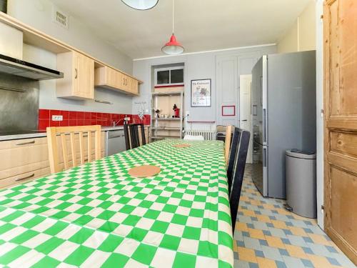 une cuisine avec une table à carreaux verts et blancs dans l'établissement Hypercentre Cholet, grande capacité 10 personnes max, 4 chambres, à Cholet